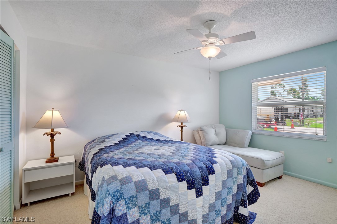 17508 Laurel Valley Road Fort Myers, FL 33967 - Photo 27 of 36 a bedroom with a bed and a chandelier