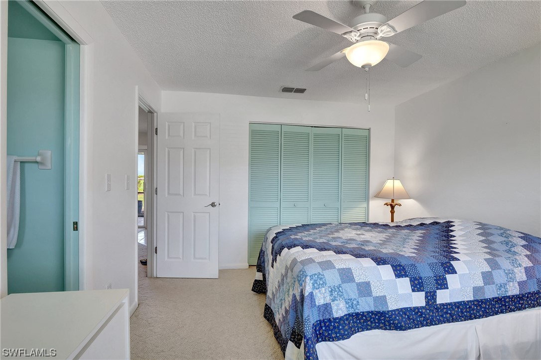 17508 Laurel Valley Road Fort Myers, FL 33967 - Photo 28 of 36 a bedroom with a bed and a chandelier