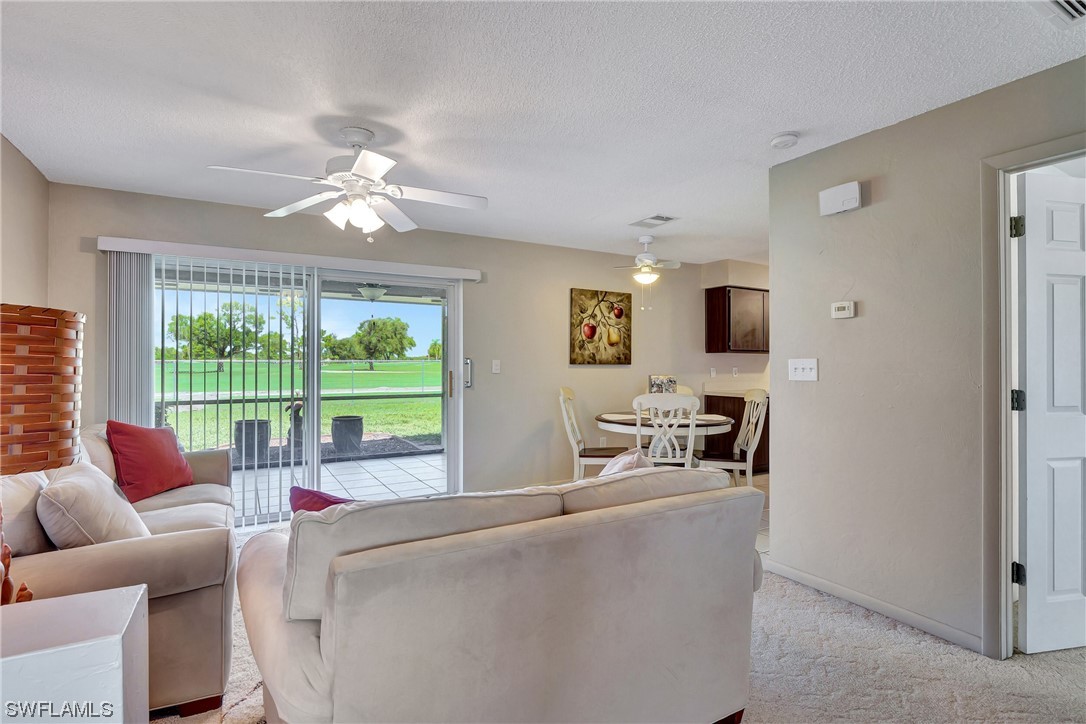17508 Laurel Valley Road Fort Myers, FL 33967 - Photo 10 of 36 a living room with furniture and a floor to ceiling window