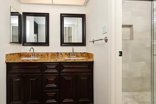a bathroom with a granite countertop sink and a mirror