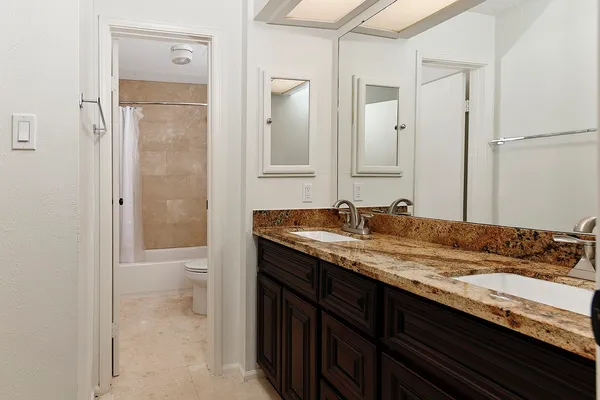 a bathroom with a granite countertop sink and a mirror