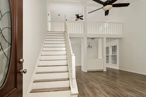 a view of a hallway with wooden floor and staircase