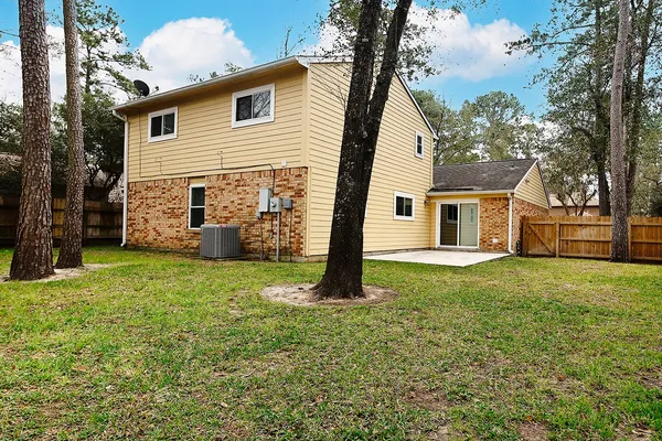 a view of a house with backyard and a tree