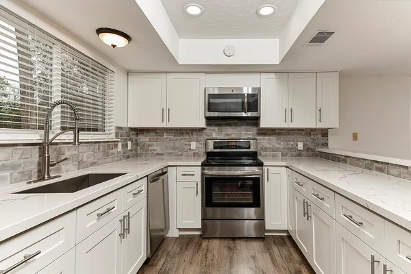 a kitchen with a sink stove and microwave