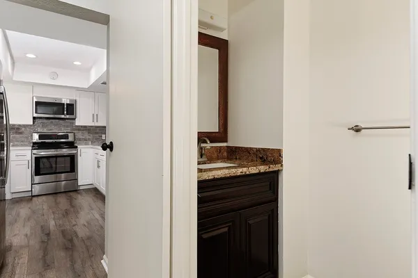a view of kitchen with sink and refrigerator