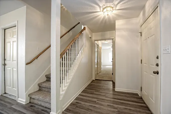 a view of a hallway with wooden floor and staircase