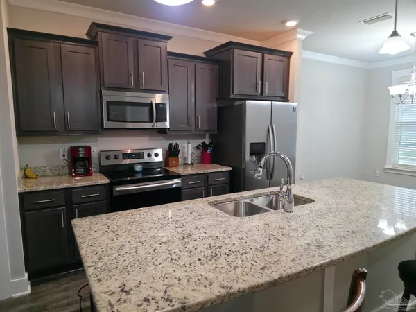 a kitchen with stainless steel appliances granite countertop a sink refrigerator and microwave
