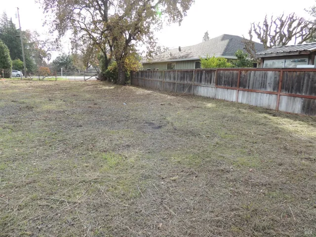 a view of a backyard with wooden fence
