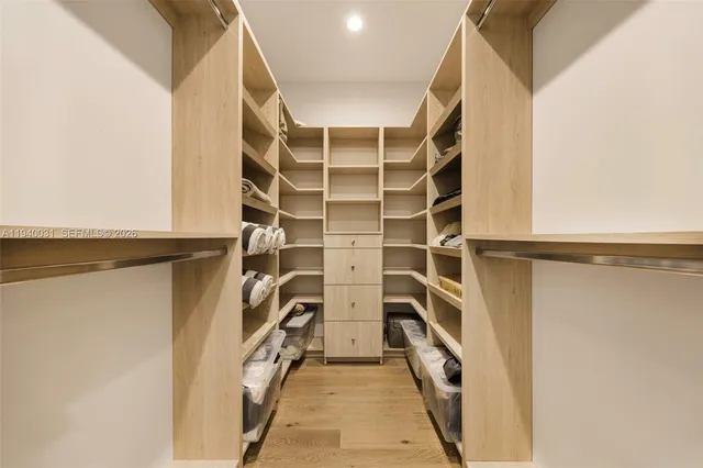 a view of walk in closet with clothes and shoes