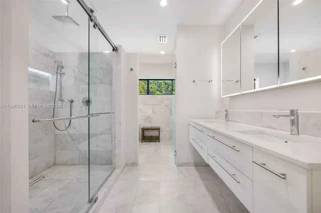 a bathroom with a double vanity sink mirror and shower