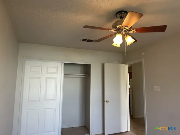a view of a chandelier fan and a refrigerator