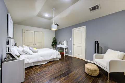 a bedroom with bed and wooden floor