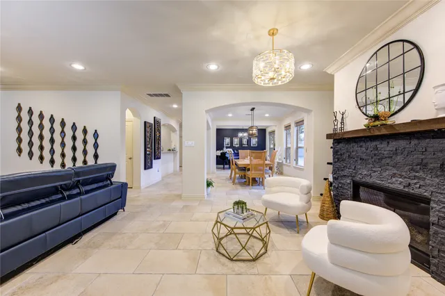 a living room with furniture a fireplace and a chandelier