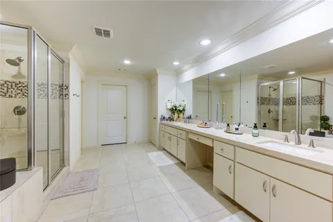 a large bathroom with a double vanity sink a large mirror and shower