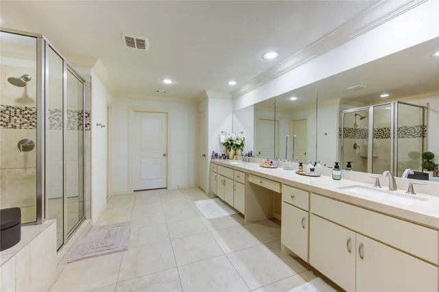 a large bathroom with a double vanity sink a large mirror and shower