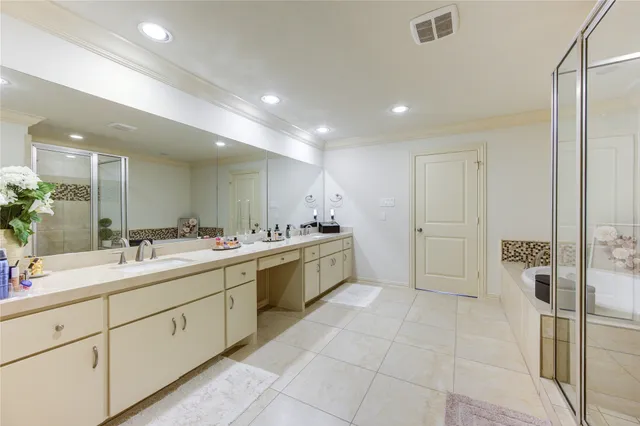 a large white bathroom with a double vanity sink a mirror and a shower
