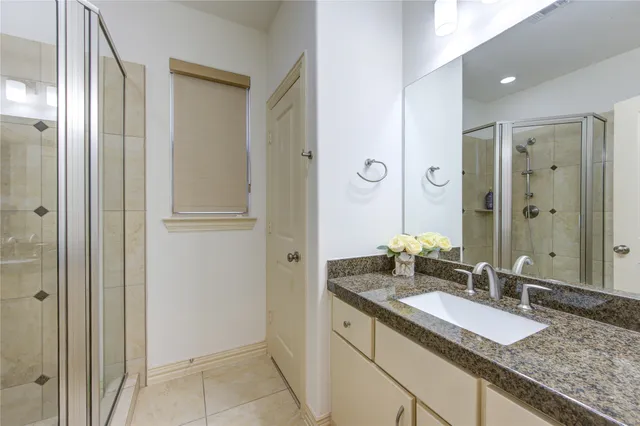 a bathroom with a granite countertop double vanity sink and mirror