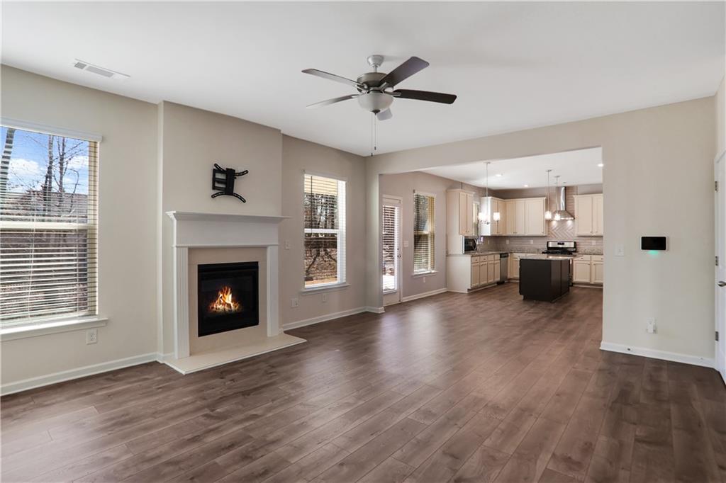 7139 Southface Way Southwest Austell, GA 30168 - Photo 8 of 27 a view of a livingroom with a fireplace a ceiling fan and windows