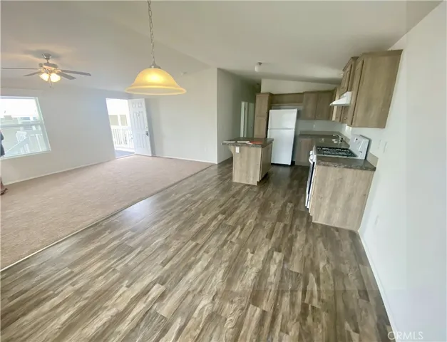 a view of a kitchen with wooden floor and electronic appliances