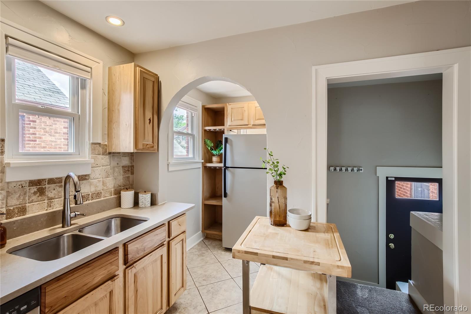 3449 Monroe Street Denver, CO 80205 - Photo 5 of 16 a kitchen with a sink and a refrigerator