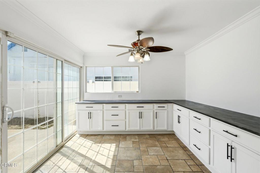 2082 Belgrave Court Simi Valley, CA 93063 - Photo 21 of 56 a large white kitchen with granite countertop a white stove a sink a window and a glass door