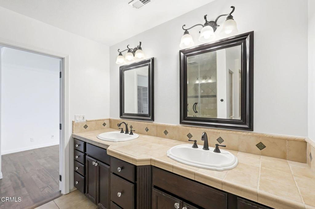 2082 Belgrave Court Simi Valley, CA 93063 - Photo 33 of 56 a bathroom with a granite countertop sink and a mirror