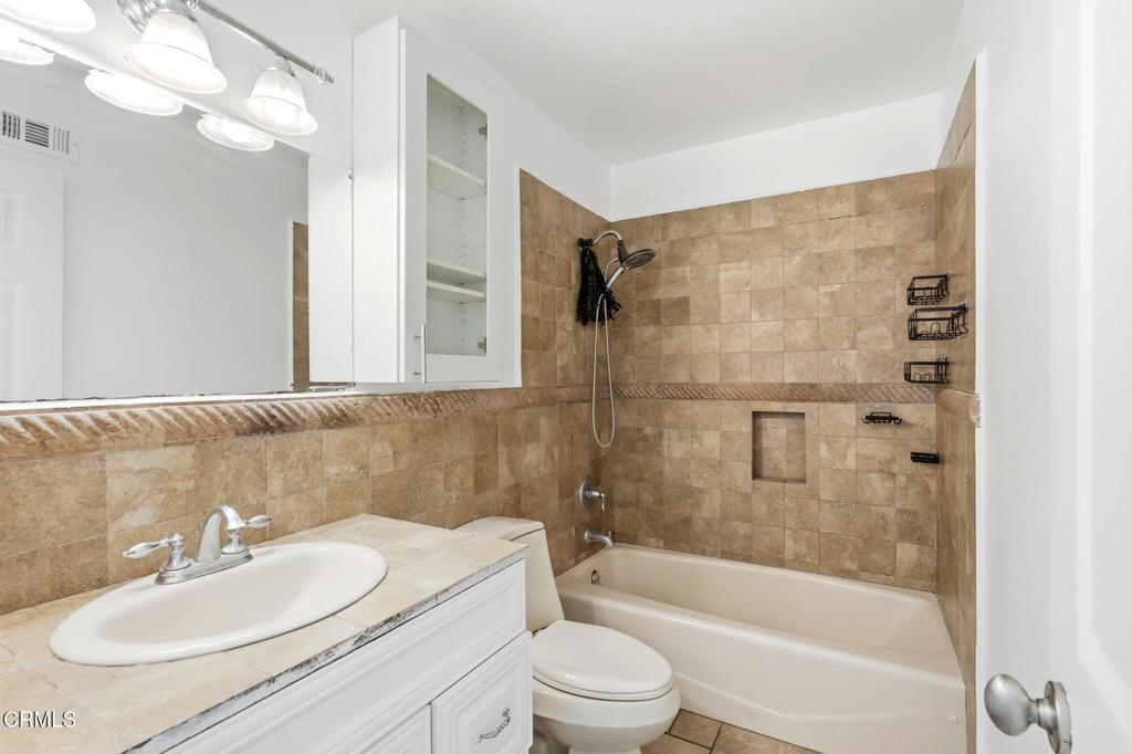 2082 Belgrave Court Simi Valley, CA 93063 - Photo 40 of 56 a bathroom with a granite countertop sink toilet mirror and shower