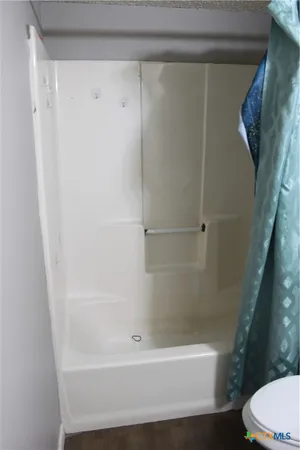a bathroom with a shower and a toilet