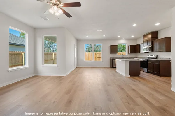 a view of a hallway with wooden floor and windows