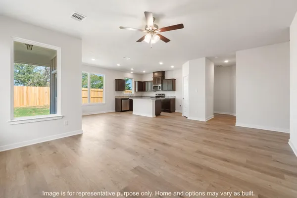 a view of kitchen with kitchen island wooden floors and stainless steel appliances