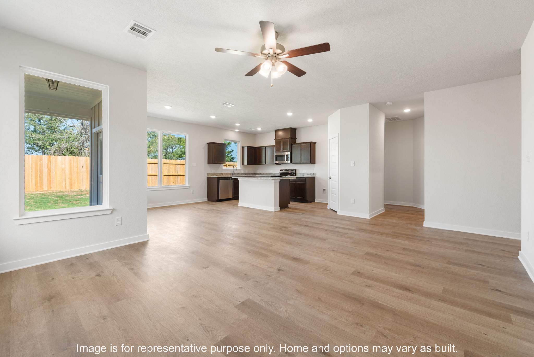 232 Gus Loop Georgetown, TX 78626 - Photo 14 of 22 a view of a kitchen with a stove cabinets a ceiling fan and wooden floor