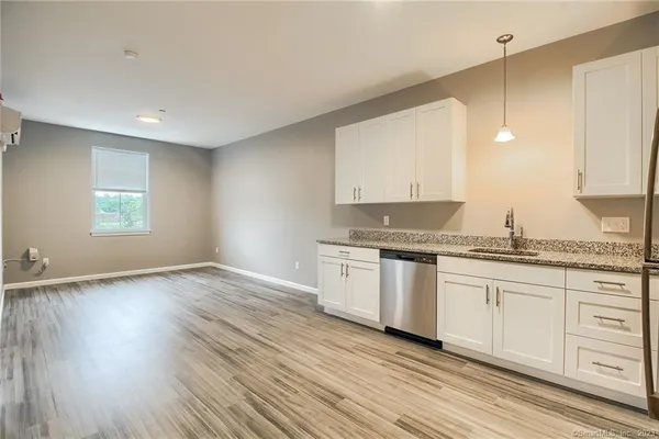 a kitchen with granite countertop white cabinets and white appliances