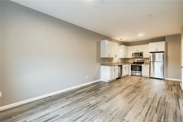 a kitchen with wooden floors and stainless steel appliances
