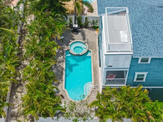 a kitchen with stainless steel appliances granite countertop a sink a stove a refrigerator with white cabinets and wooden floor