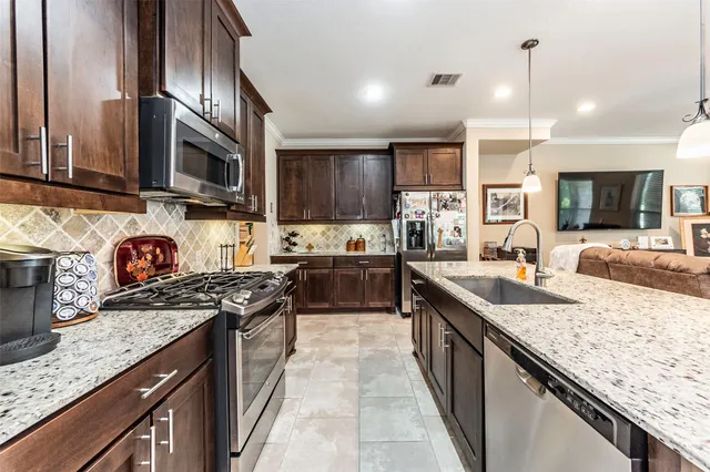 a kitchen with stainless steel appliances granite countertop a sink stove and refrigerator