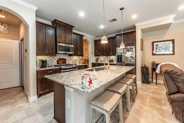 a kitchen with stainless steel appliances granite countertop a sink refrigerator and cabinets
