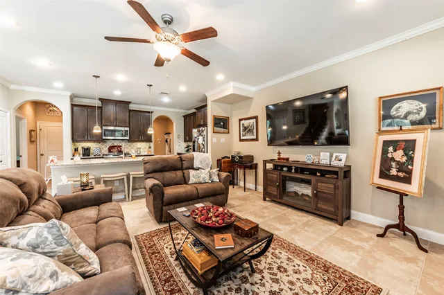 a living room with furniture ceiling fan and a flat screen tv