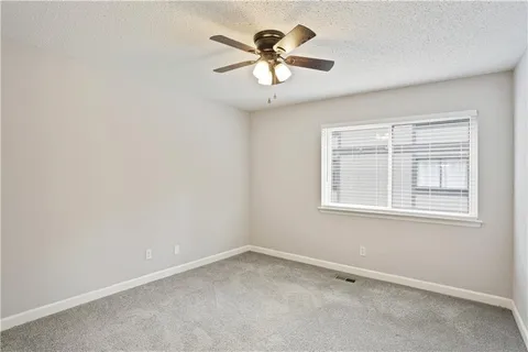 an empty room with a window and a ceiling fan