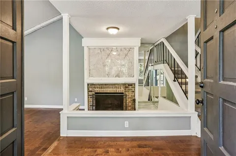 a living room with a fireplace and a floor to ceiling window