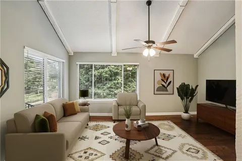 a living room with furniture a large window and a flat screen tv