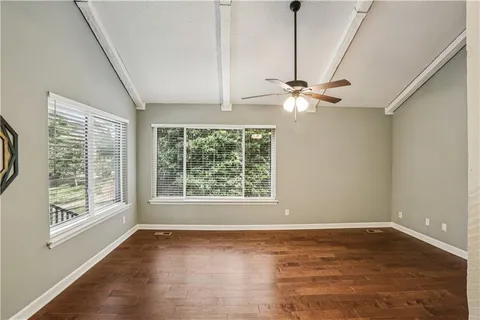 a view of an empty room with a window and a ceiling fan
