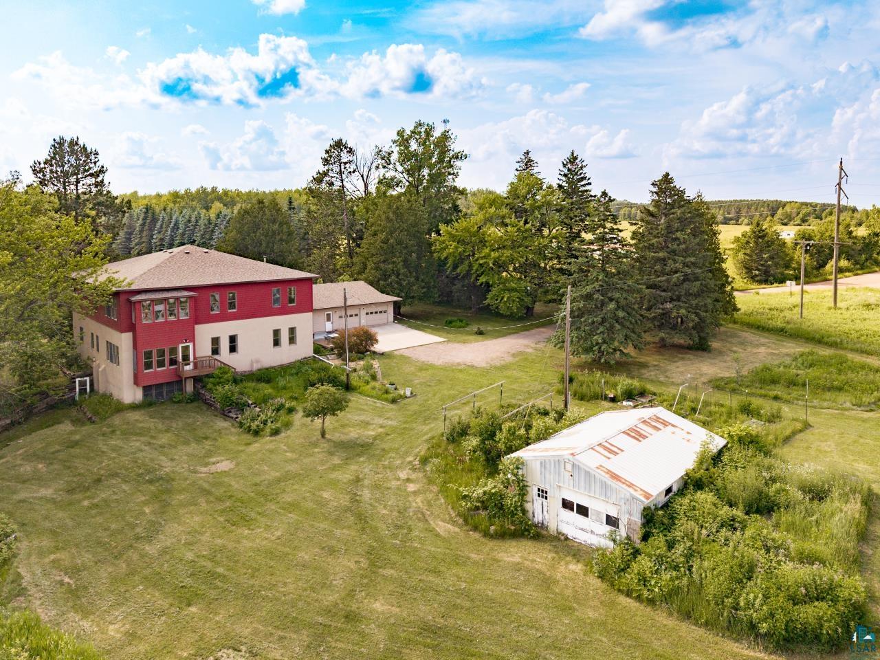 4800 Tower Road Moose Lake, MN 55767 - Photo 32 of 83 Multi-level residence featuring a red and tan exterior, a multi-car garage, and a driveway