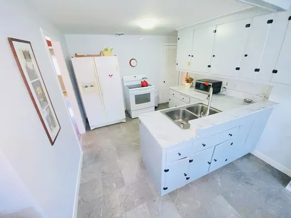 a kitchen with cabinets and white appliances