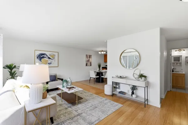 a living room with furniture and a wooden floor
