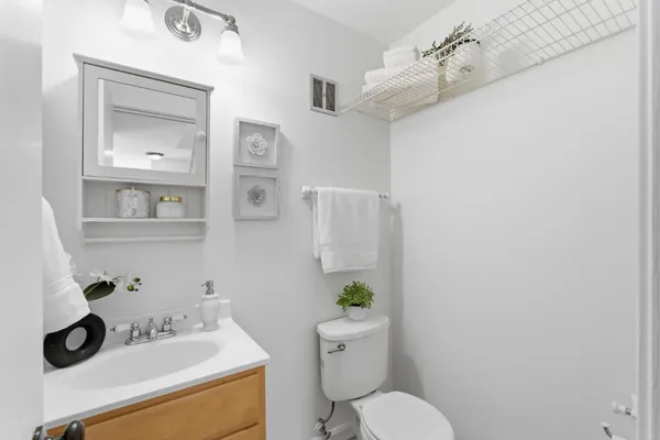 a bathroom with a sink mirror vanity and toilet