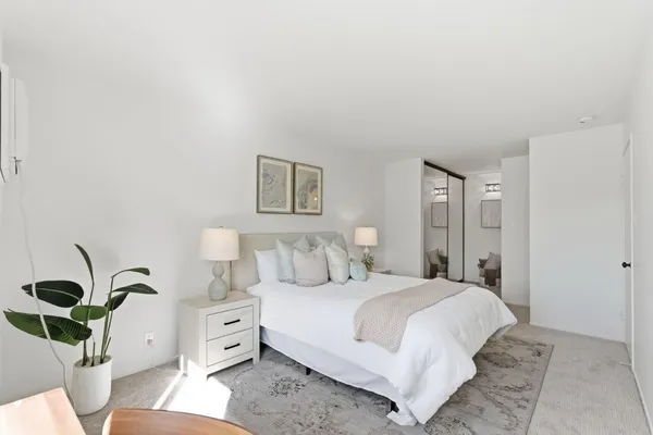 a bedroom with a bed and a potted plant