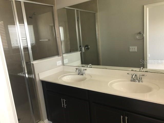 8549 Pinter Street Orlando, FL 32827 - Photo 18 of 25 a bathroom with double sink and a mirror
