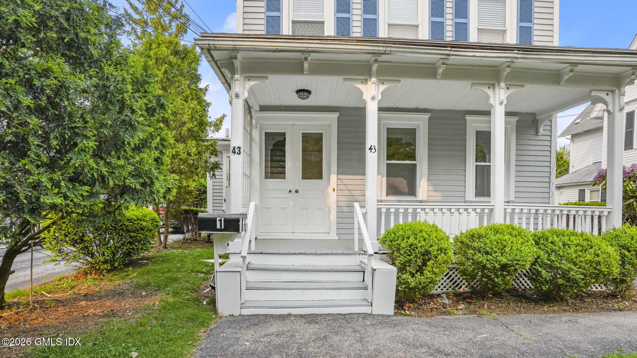 43 Church Street, Unit 1 Greenwich, CT 06830 - Photo 2 of 17 a front view of a house with plants and garden
