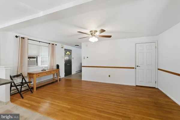 a view of an empty room with window and a ceiling fan