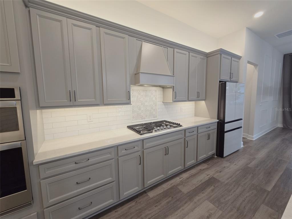 6349 Mossy Oak Road St. Cloud, FL 34771 - Photo 11 of 82 a kitchen with granite countertop wooden cabinets and white appliances